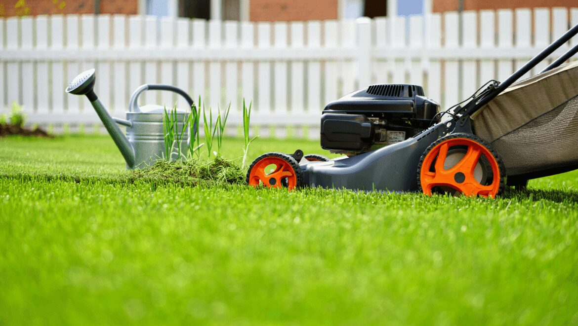 A close-up shot of several gardening tools and equipment, placed on clean turf, showcasing April lawn care