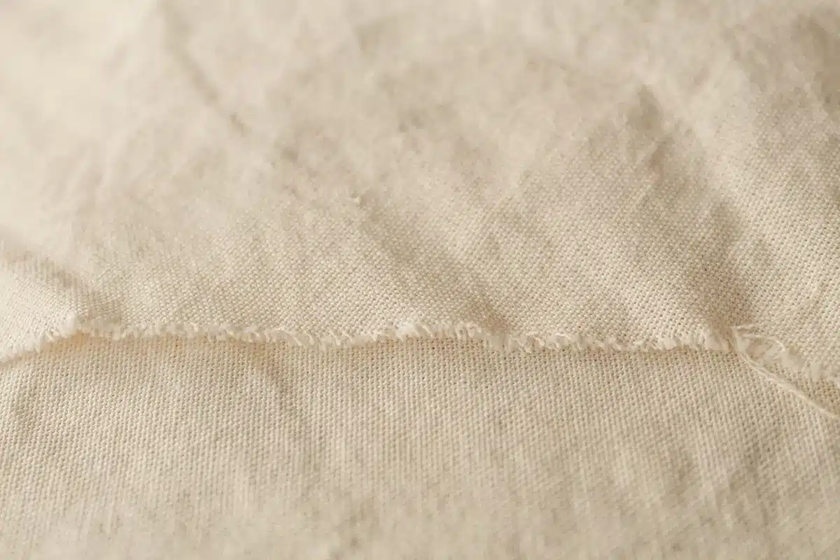 Gros plan sur une texture de tissu naturel respirant montrant les fibres du lin et du coton.