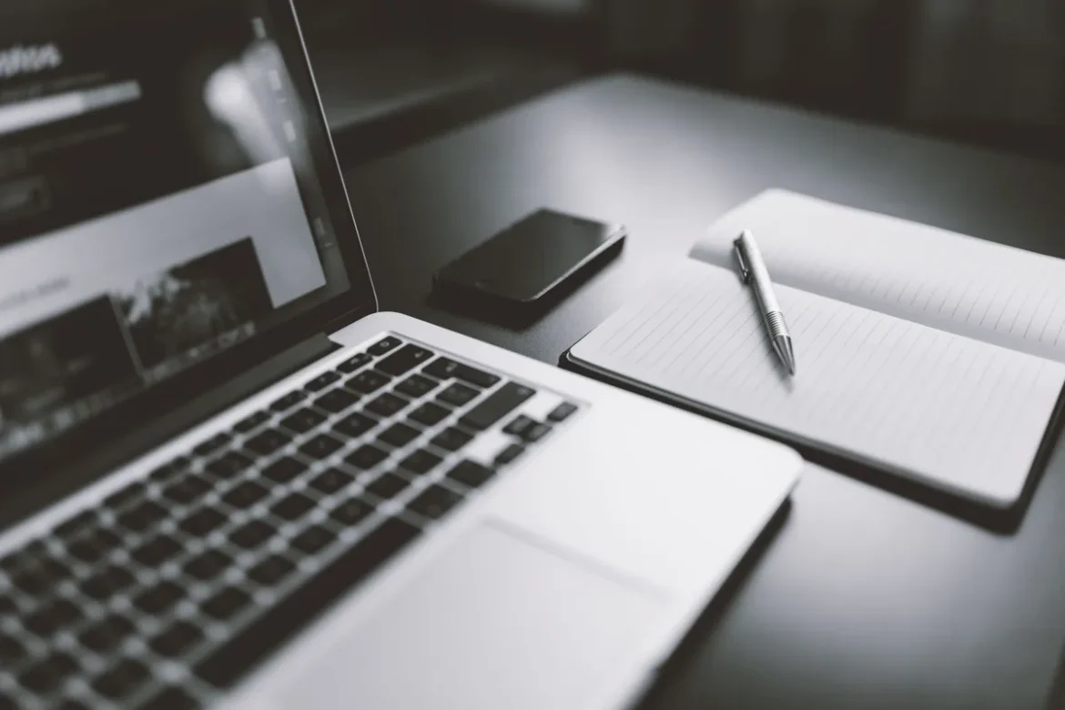 Professionnel rédigeant une biographie sur son ordinateur portable au bureau
