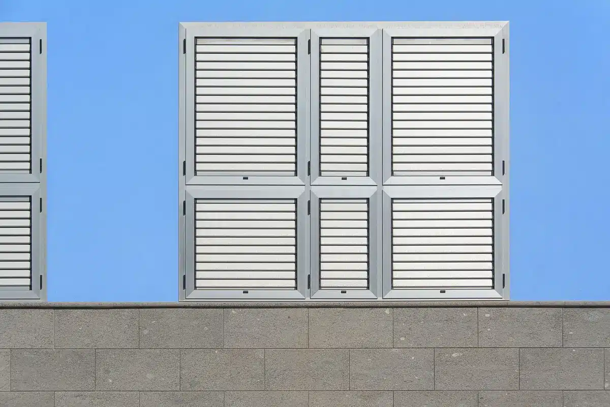 Comparaison de trois types de volets : bois, PVC et aluminium sur une maison
