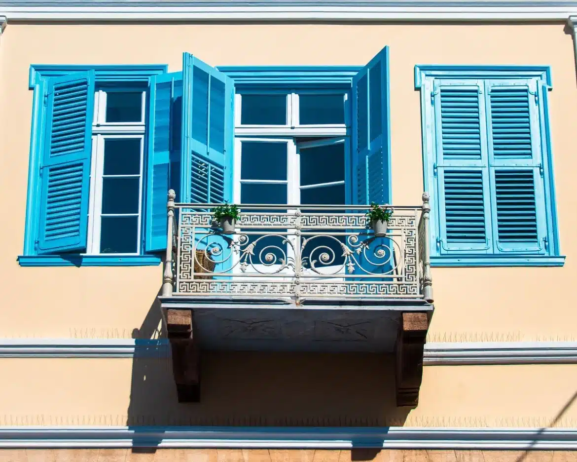 Volets fermés sur une façade résidentielle exposée au soleil en pleine journée
