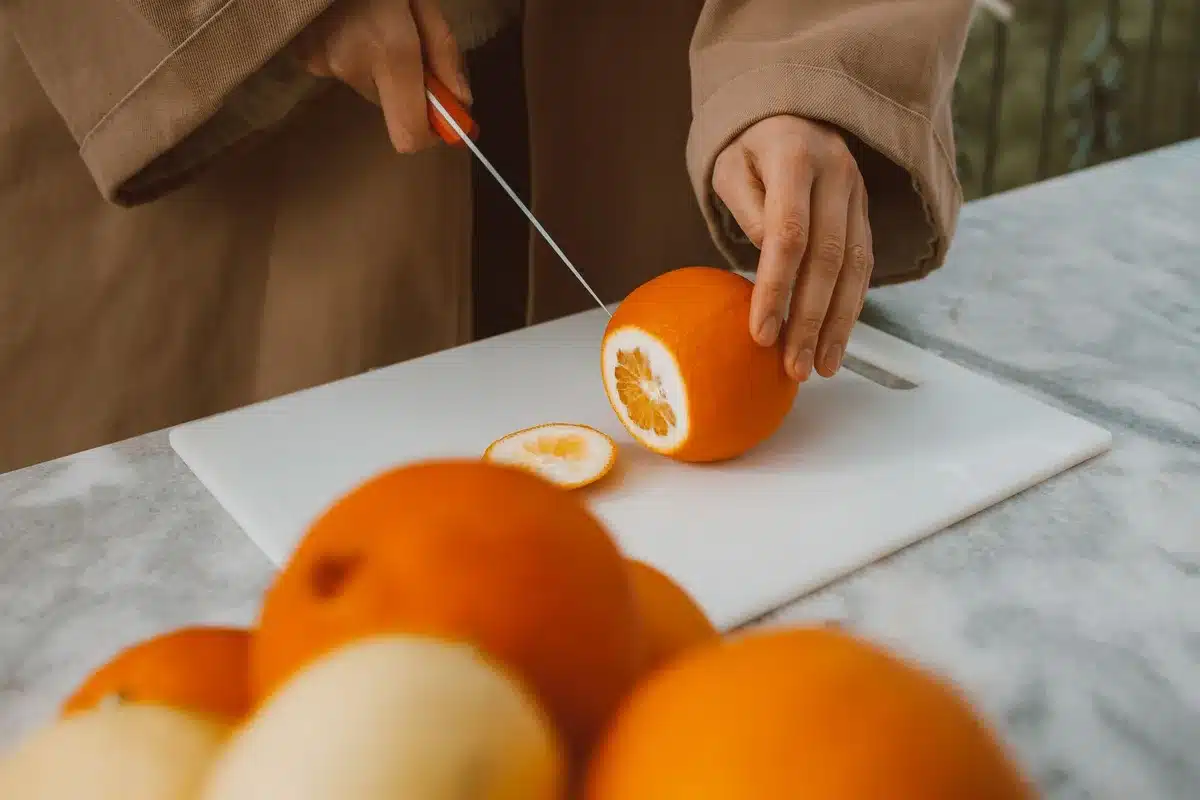 Écorces d'orange fraîches découpées en petits morceaux pour libérer les huiles essentielles.