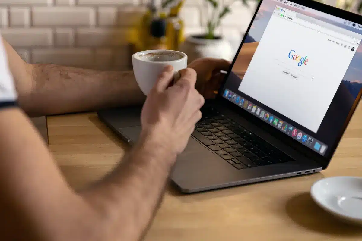 Personne vérifiant des résultats de recherche sur plusieurs moteurs depuis un ordinateur