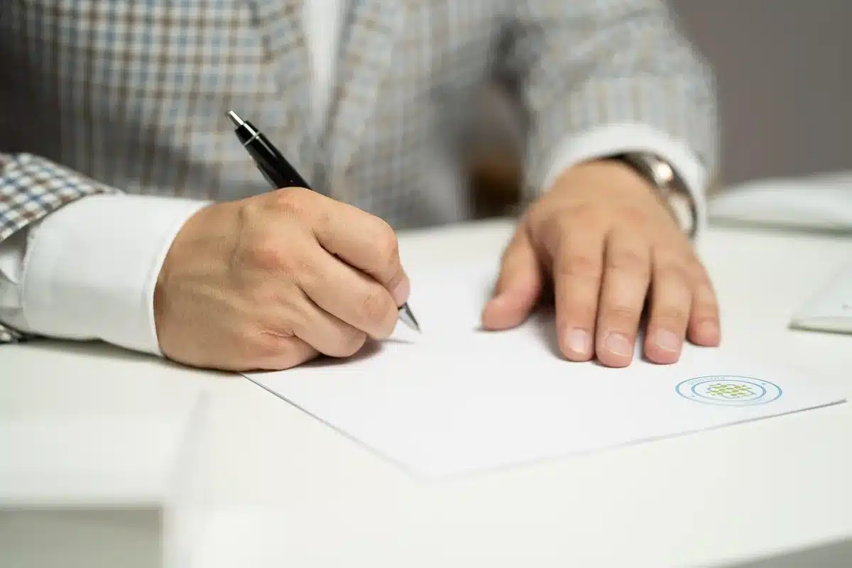Main feuilletant des registres d'archives sur une table en journée