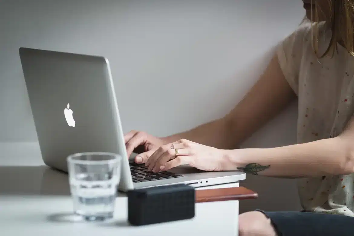 Bureau clair avec dossiers, ordinateur portable et fenêtres laissant entrer la lumière du jour