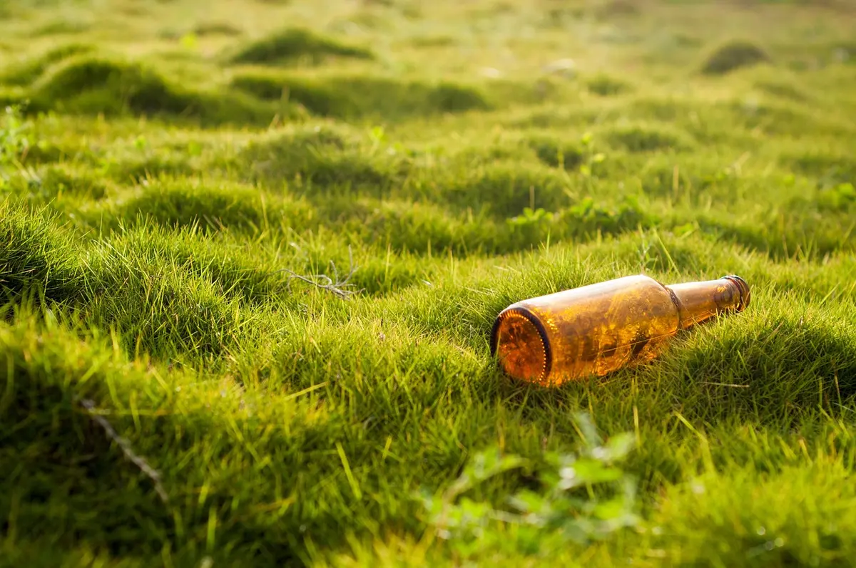 Vaporisateur, bouteille de citron et éponge non abrasive sur un plan de travail