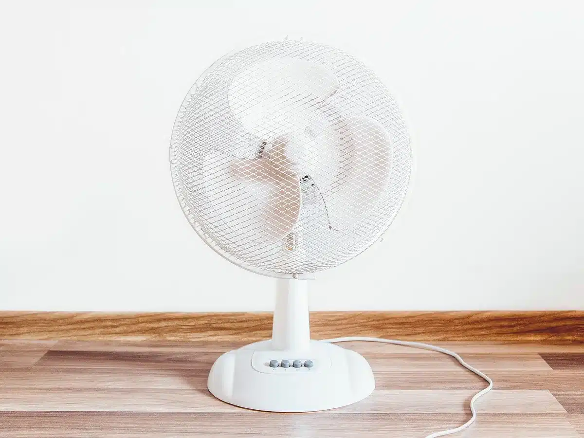 Ventilateur sur pied oscillant dans une chambre spacieuse pour rafraîchir une grande surface