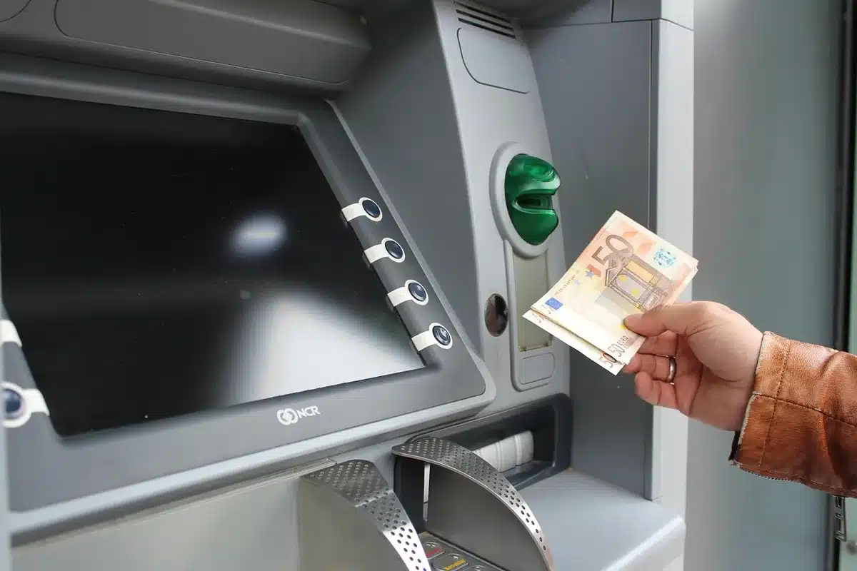 Mains déposant un billet partiellement froissé dans un automate recyclant